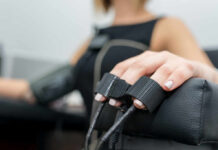 Close-up of a patients hand during a medical examination with monitoring equipment