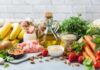 Revealed: Foods That Weaken Your Bones A variety of fresh foods including fruits, vegetables, and oils arranged on a table