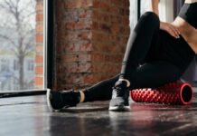 Stretching Mistakes That Could Cost You Mobility Person using a foam roller for stretching in a fitness studio