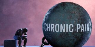 A figure representing chronic pain, sitting beside a large ball labeled 'CHRONIC PAIN' chained to their body