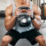 Athlete performing a kettlebell squat in a gym