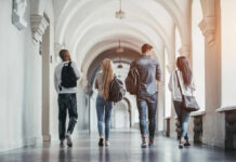 Group of students walking together in a university hallway