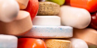 A close-up view of a variety of colorful pills and tablets stacked together