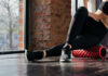 Person using a foam roller for stretching in a fitness studio