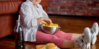 Child sitting on the floor enjoying snacks from a bowl