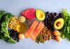 Protein Breakfasts That Kill Cravings Fast An assortment of healthy foods including fish, nuts, fruits, and vegetables arranged on a light background