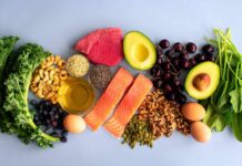 Protein Breakfasts That Kill Cravings Fast An assortment of healthy foods including fish, nuts, fruits, and vegetables arranged on a light background
