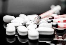 Revolutionary Test Stops Antibiotic Overuse White pills and syringes arranged on a reflective surface
