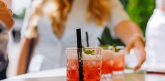 Close-up of cocktails on a table with a person reaching for one