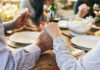 Couple holding hands over a dining table with food and drinks