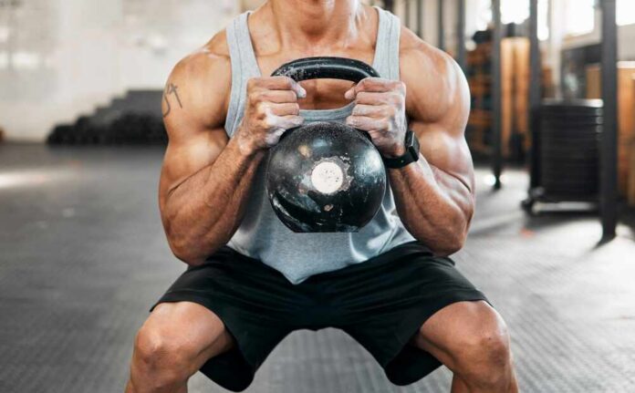 Athlete performing a kettlebell squat in a gym