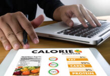 Diet Swap That Reverses Aging in Seniors Person using a calorie counter app on a tablet while working on a laptop