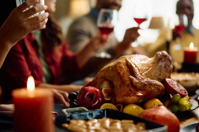 shutterstock2376308555jpg A beautifully roasted turkey surrounded by fruits and candles on a festive dining table