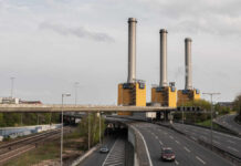 The City Pollutant Quietly Clogging Your Arteries Industrial power plant with three tall smokestacks beside a highway
