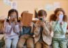 How Bad News Overload is Rewiring your Brain Four children sitting together, each engaged with their electronic devices
