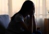 Emotional Suppression—The Silent Health Risk A silhouette of a person sitting with their head in their hands, conveying distress