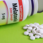 Insomnia: Why Pills No Longer Reign Bottle of melatonin tablets with some pills spilled on a green surface