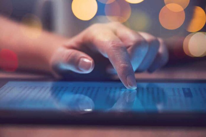 shutterstock_1024804060 Hand tapping a tablet screen