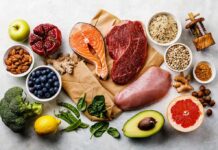 Assorted healthy foods with salmon, beef, chicken, fruits, vegetables, nuts, and grains