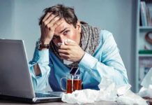When “Just a Flu” Drowns Lungs and Turns Fatal Sick man at desk blowing his nose
