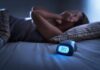 Therapy Breakthrough Tops Drugs in Insomnia Battle Person lying awake in bed beside a glowing digital alarm clock