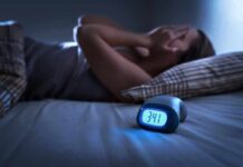 Therapy Breakthrough Tops Drugs in Insomnia Battle Person lying awake in bed beside a glowing digital alarm clock