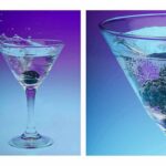 Martini glass with blackberries splashing into sparkling water
