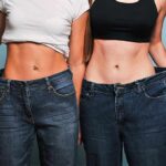 Two women showing loose jeans at the waist