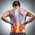 Man holding lower back with highlighted spine illustration