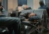 Passengers sleeping on airport benches with luggage nearby
