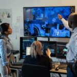 Security team monitors multiple surveillance screens in control room