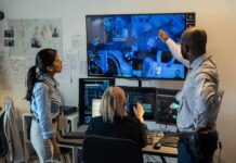 Security team monitors multiple surveillance screens in control room