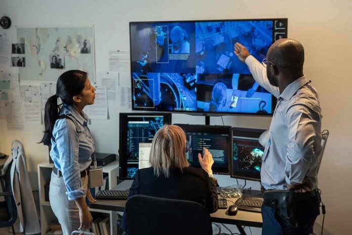Security team monitors multiple surveillance screens in control room