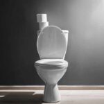 White toilet with open lid against gray wall