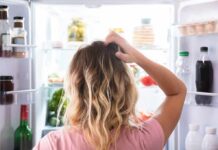 Person looking into an open refrigerator