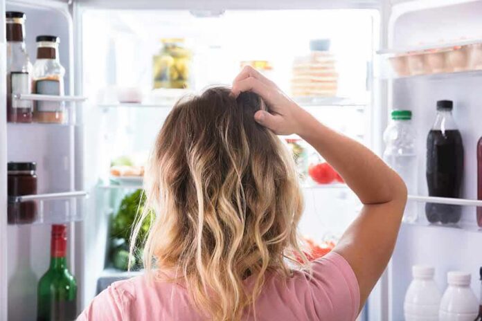 Person looking into an open refrigerator