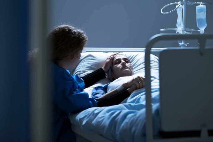 shutterstock_1030133815 Patient in hospital bed with visitor holding their hand