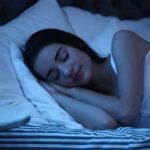 Woman sleeping on her side in bed