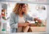 Woman unpacking groceries into a refrigerator