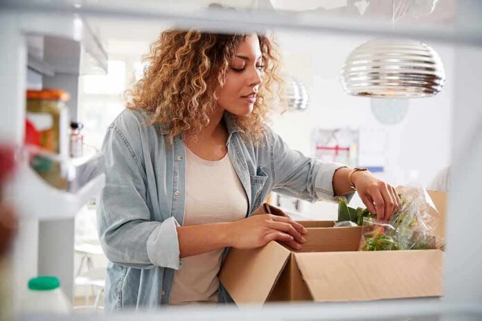 Woman unpacking groceries into a refrigerator