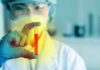 Scientist holding a test tube with red liquid