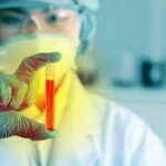 Scientist holding a test tube with red liquid