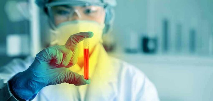 Scientist holding a test tube with red liquid