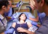 Patient on hospital gurney surrounded by medical staff