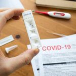 Hand holding a COVID-19 rapid test cassette