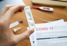 Hand holding a COVID-19 rapid test cassette