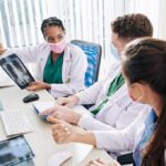 Doctors reviewing chest X-ray at a workstation