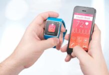 When Sleep and Fitness Wearables Wreck Health hands holding a smartwatch and a smartphone with health app