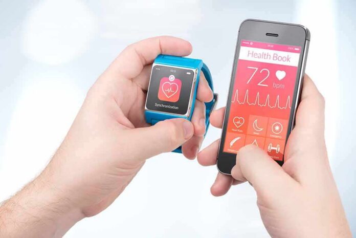 hands holding a smartwatch and a smartphone with health app