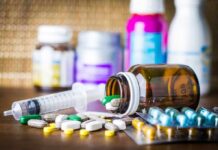 Telehealth ‘Pill Mills’: The future of medicine? Medicine pills and syringe on table with brown bottle